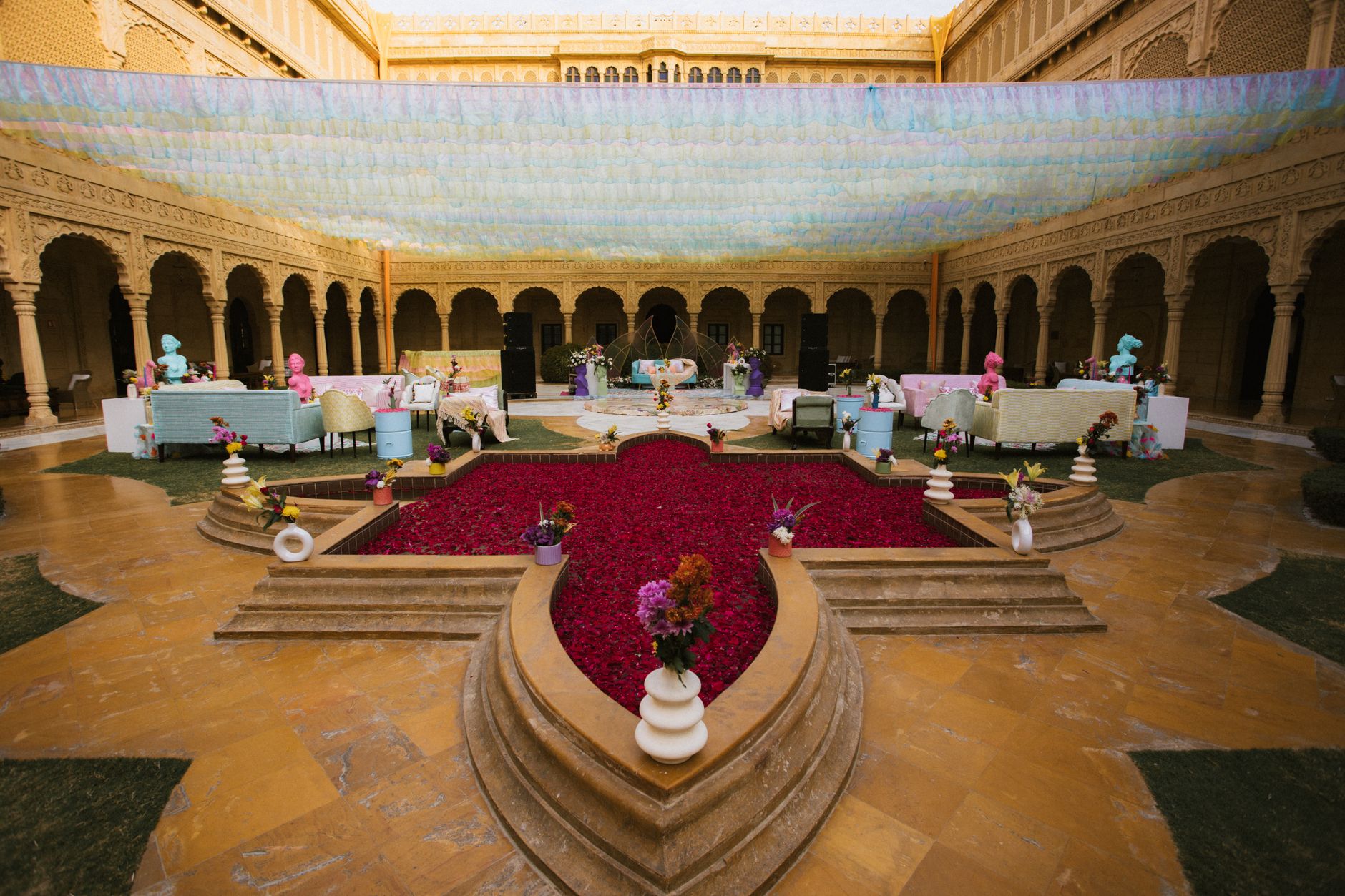 Vibrant courtyard with colorful decor and rose petals, under ornate arches. — Beste Wedden Snooker Trucs