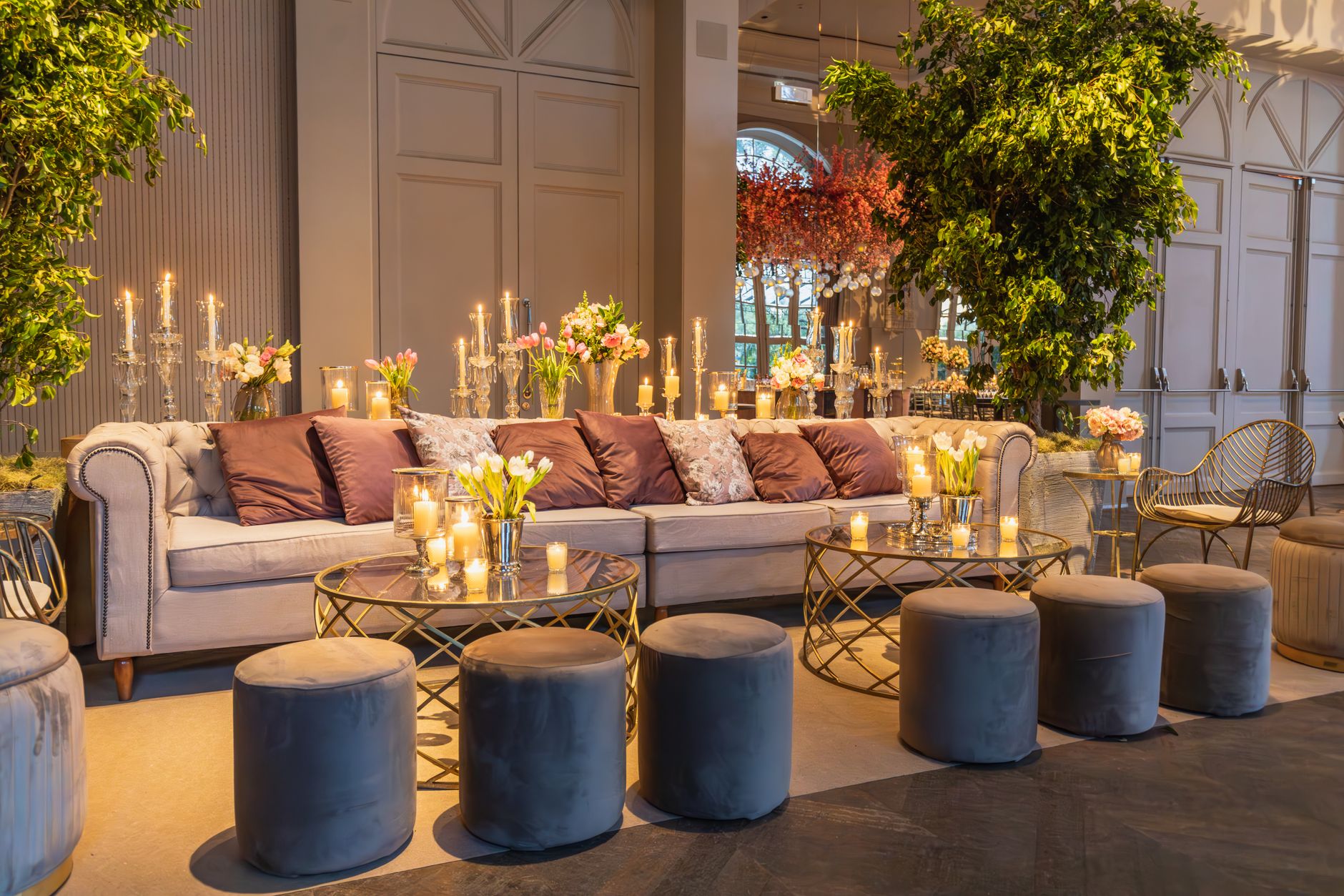 Cozy and stylish indoor lounge featuring plush seating, floral arrangements, and candlelit ambiance. — Betrouwbare Online Wed