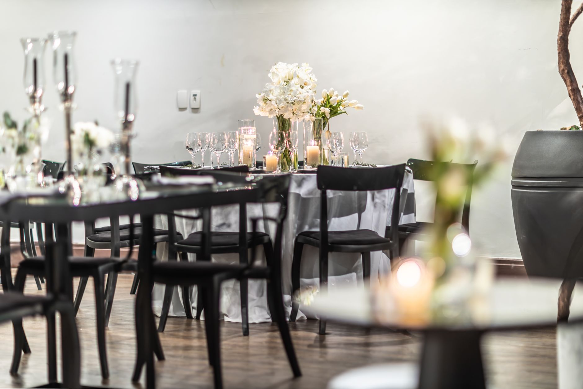 A beautifully arranged wedding reception table featuring candles and flowers, creating a warm and intimate atmosphere. — Carr