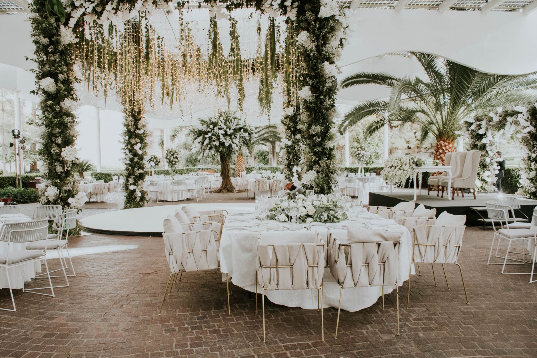 Stunning outdoor wedding setup featuring floral decorations, elegant seating, and ambient lighting. — E Wedden Trucs