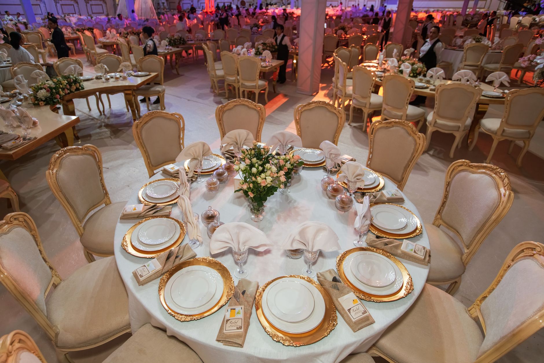 Luxurious wedding reception with elegantly decorated tables and chairs in an opulent setting. — E Wedden Trucs