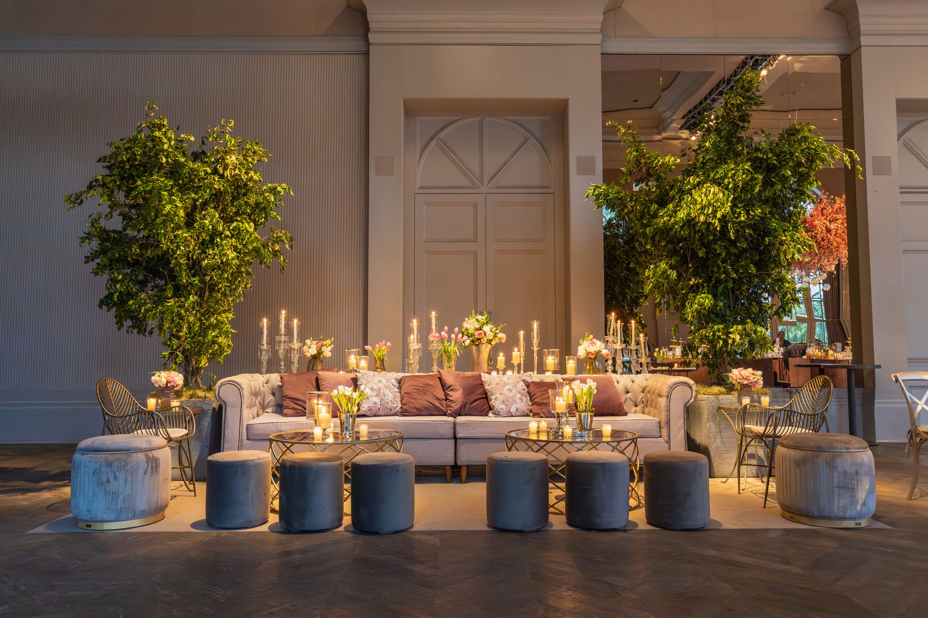 Stylish lounge setup with plush sofa, candles, and lush greenery indoors. — Engels Voetbalelftal Lets Voetbalelftal Statistie