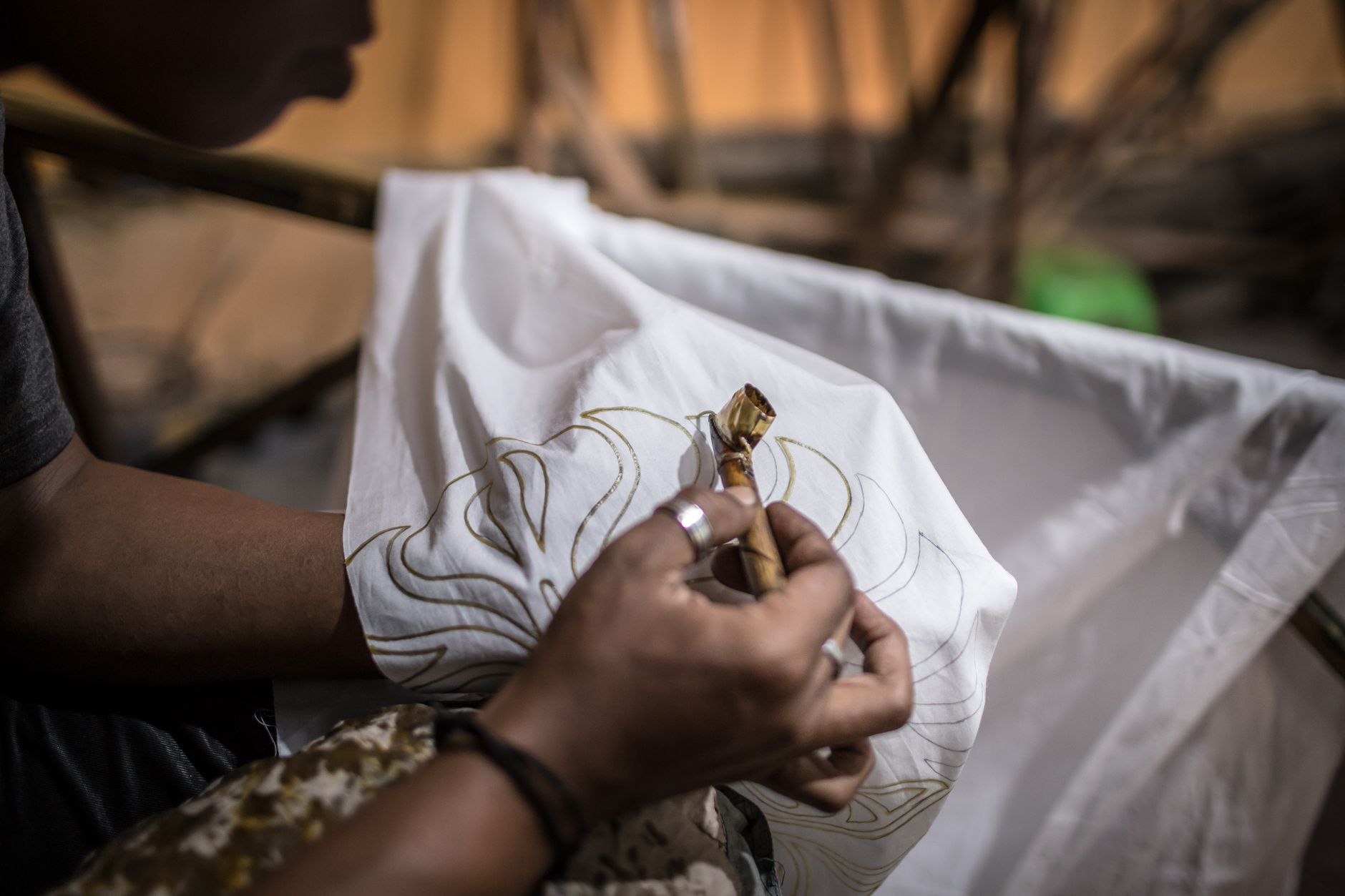 Close-up of an artisan handcrafting a traditional batik design on fabric, highlighting cultural craftsmanship. — Family Game