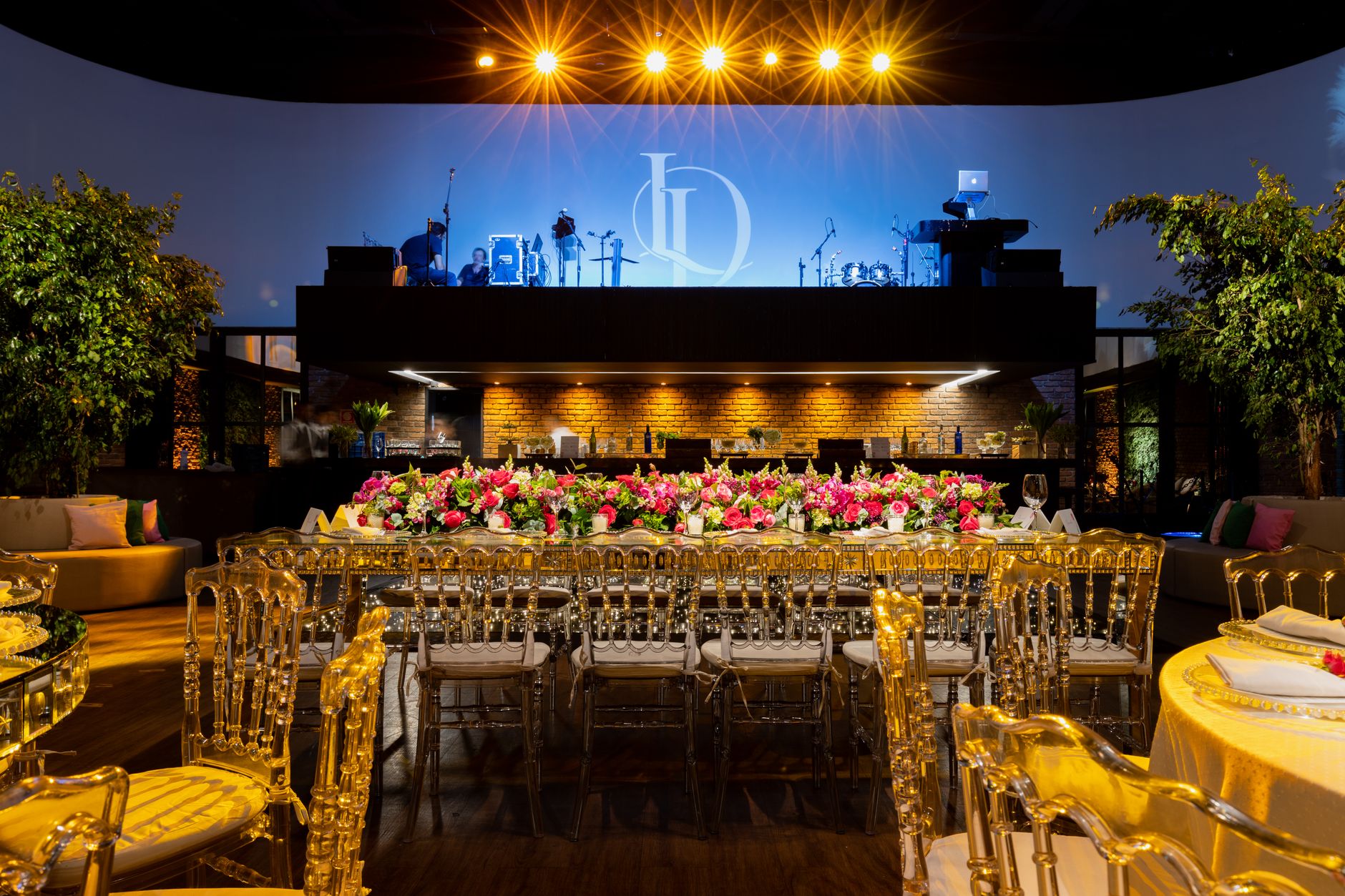 Beautiful wedding venue with luxurious floral table setting and illuminated stage. — Live Wedden Mma