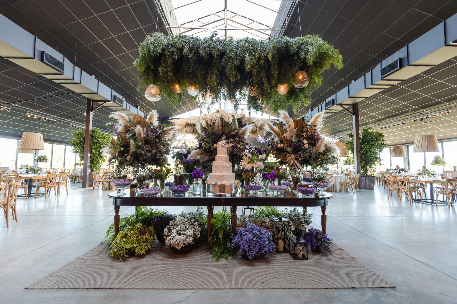 Stunning indoor wedding venue with floral arrangements and a multi-tiered cake on a decorated table. — Scommesse Juventus Rom