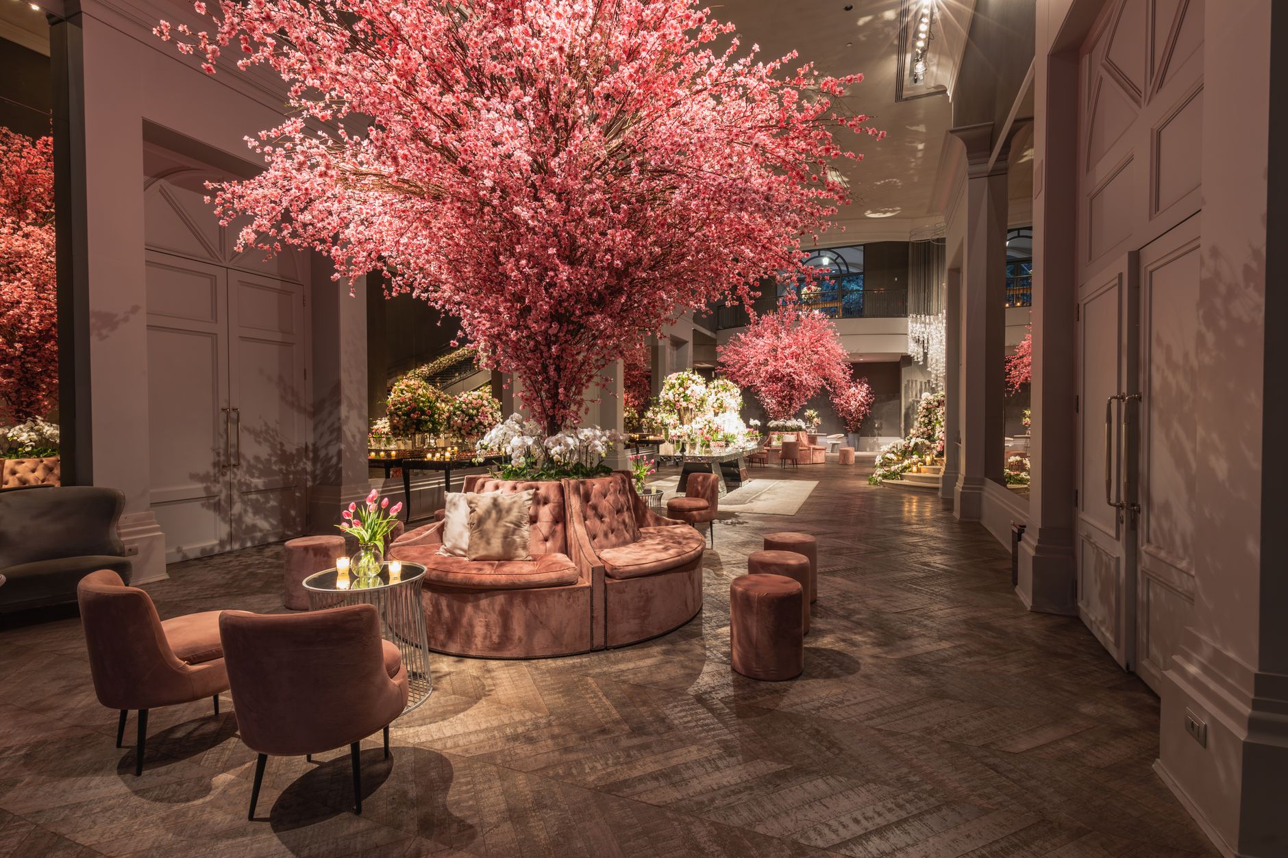 Elegant hotel lobby featuring cherry blossom arrangements and plush seating under warm lighting. — Scommettere Su Finale Euro