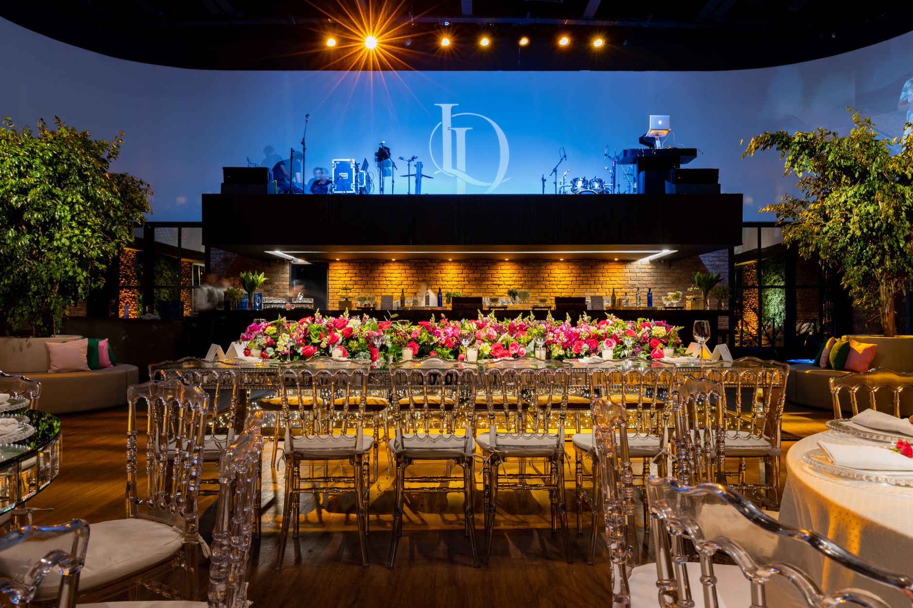 A beautifully decorated wedding venue featuring lush floral arrangements, stylish seating, and dramatic lighting. — Scommette