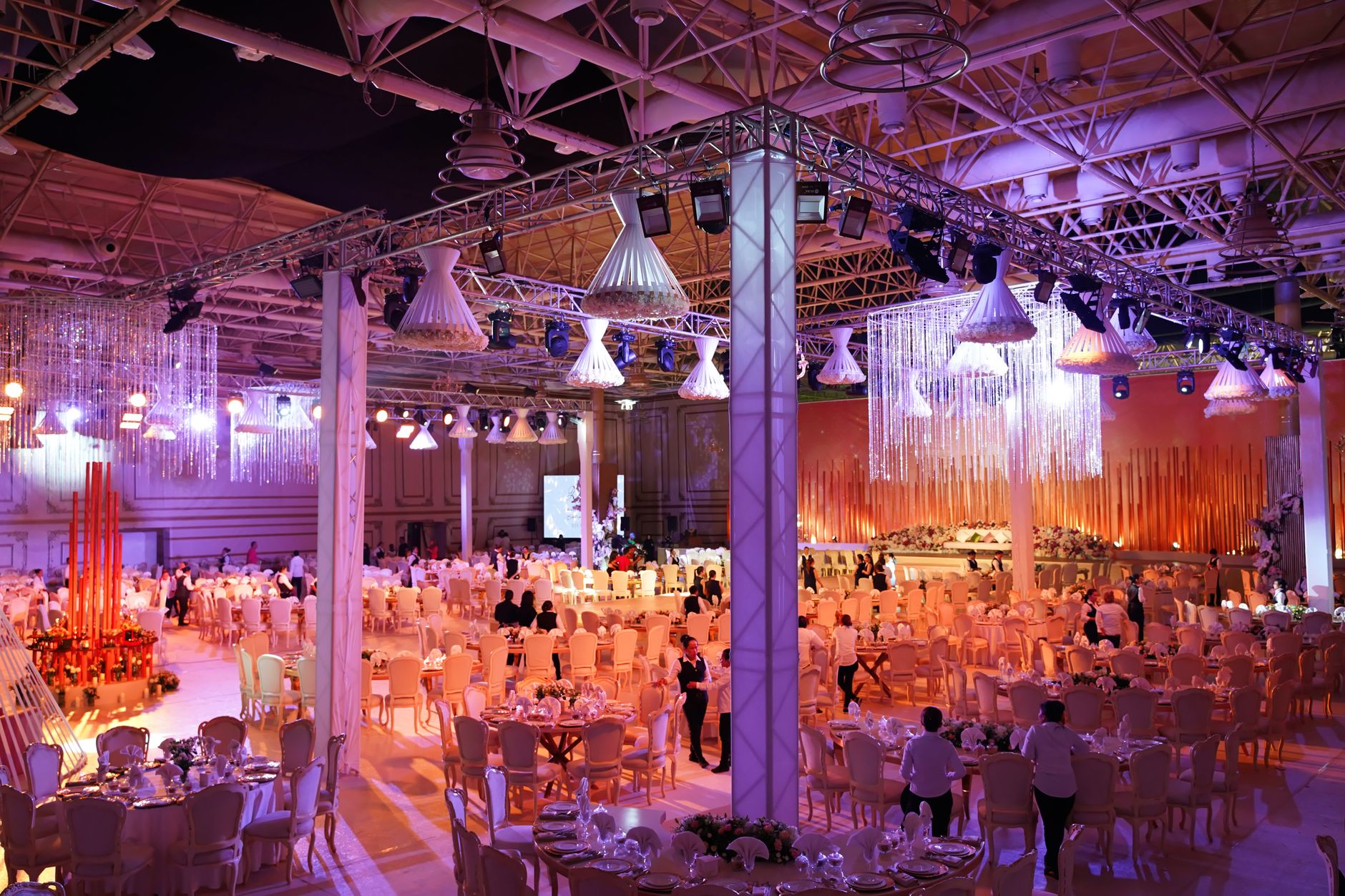 A grand indoor wedding reception with ornate lighting, tables, and a vibrant atmosphere. — Senza Pronostici Calcio Serie A