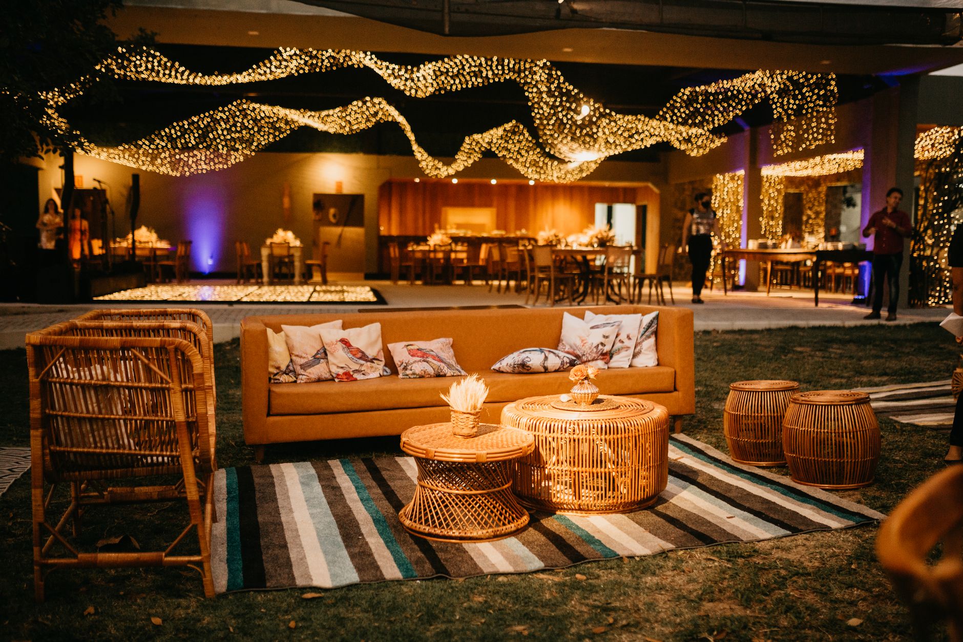 Warm outdoor seating with wicker furniture and ambient lighting for an elegant evening event. — Simulatore Partite Hockey Per