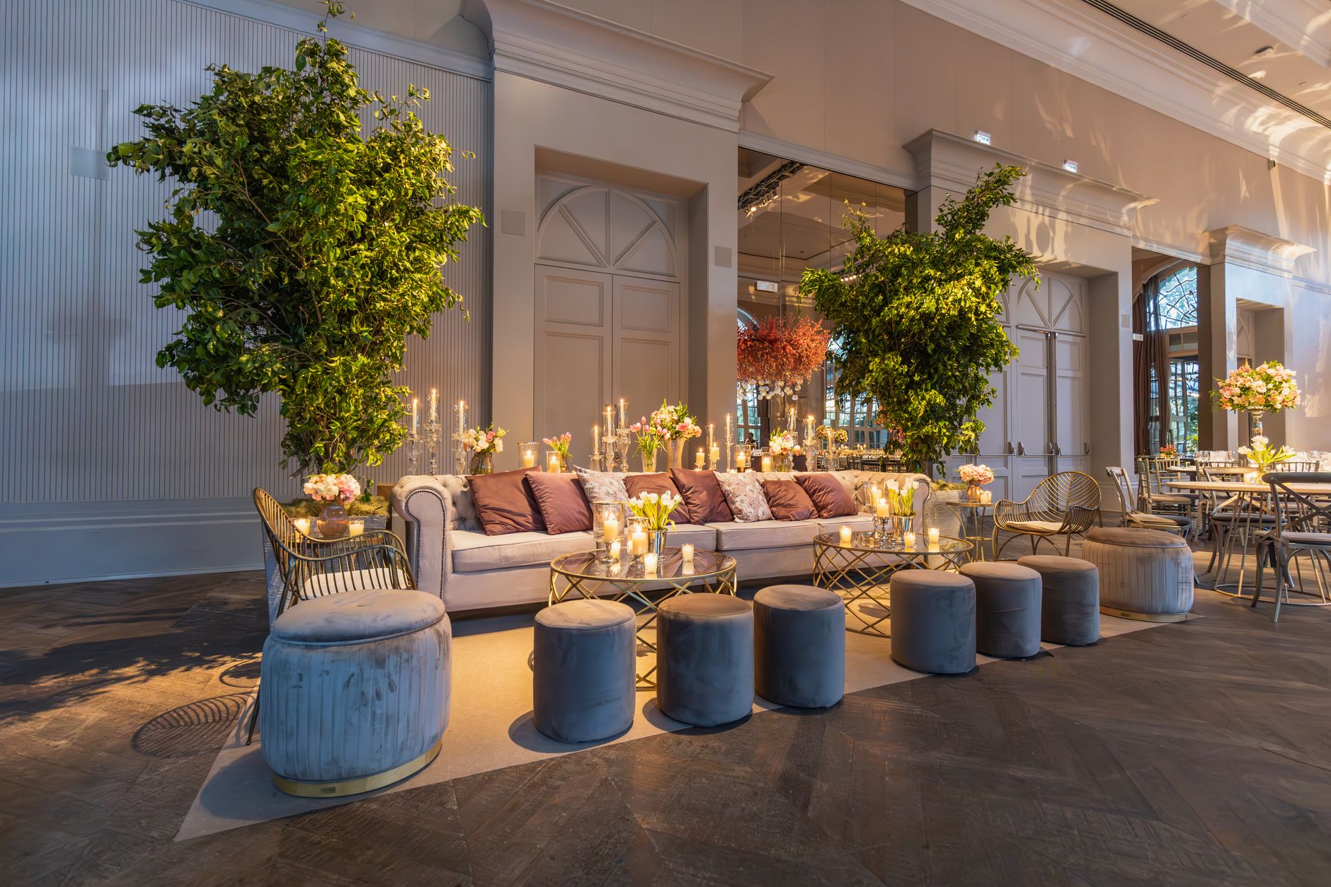 Elegant indoor lounge featuring plush seating, greenery, and candlelit ambiance. — Under Over Apuestas