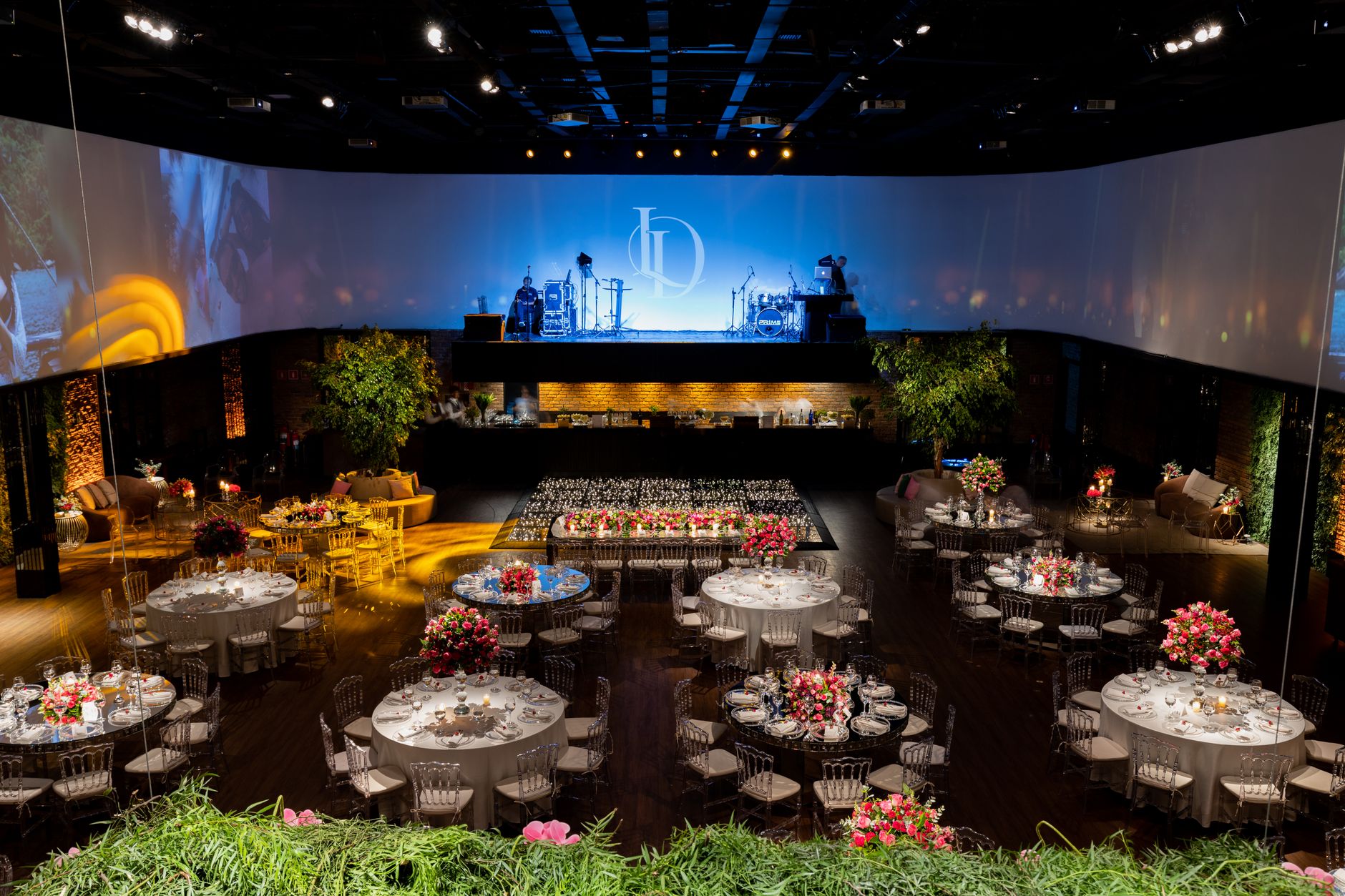 Luxurious banquet hall with floral centerpiece tables and stage setup for events. — William Hill Apuestas Deportivas Online